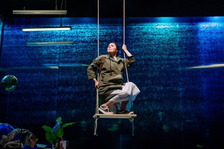 Actor crouching on a swing on the set of Earthquakes in London